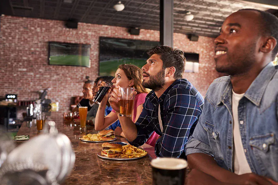 Group of friends watching football at home